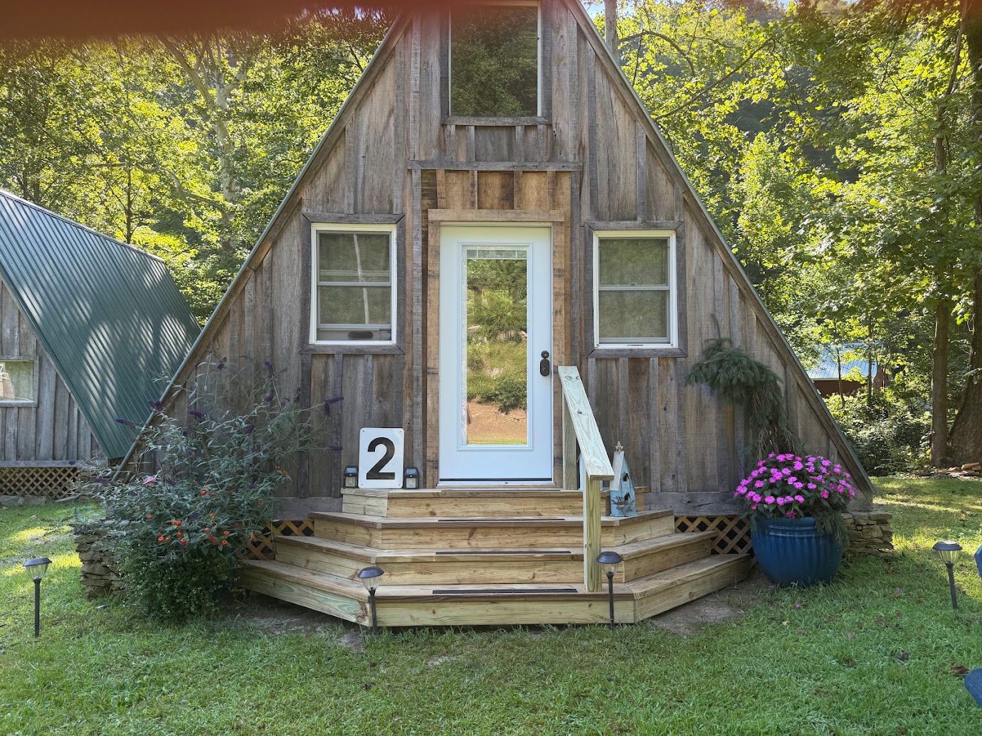 A wooden cabin with a white door, two windows, and a number '2' sign.