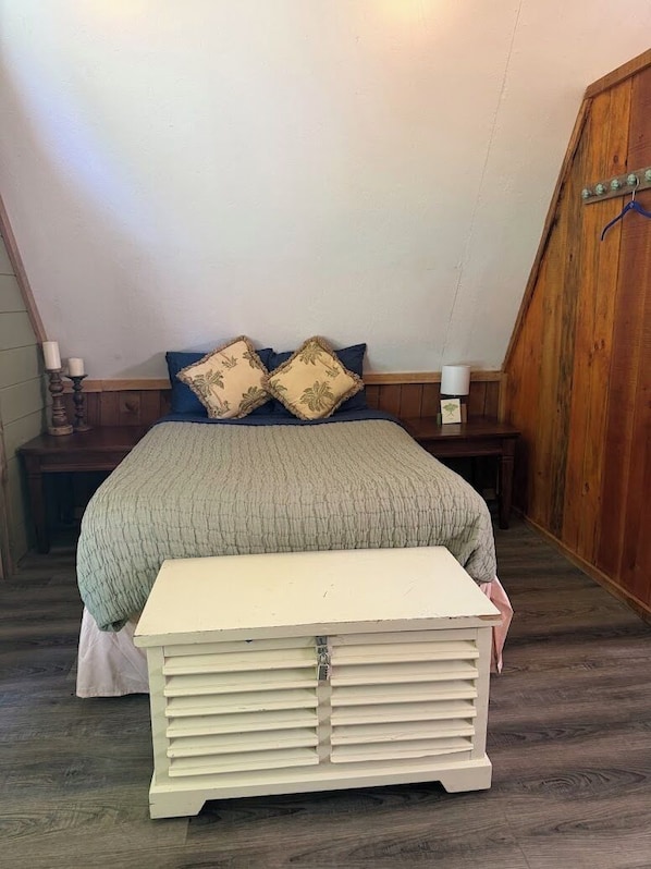 A bedroom with a bed, a bench, and a nightstand.