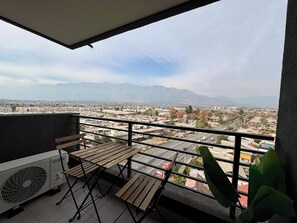 A balcony with a view of a cityscape and mountains in the distance. - 2BR Andes View - Parking, Pool & Metro (Santiago)