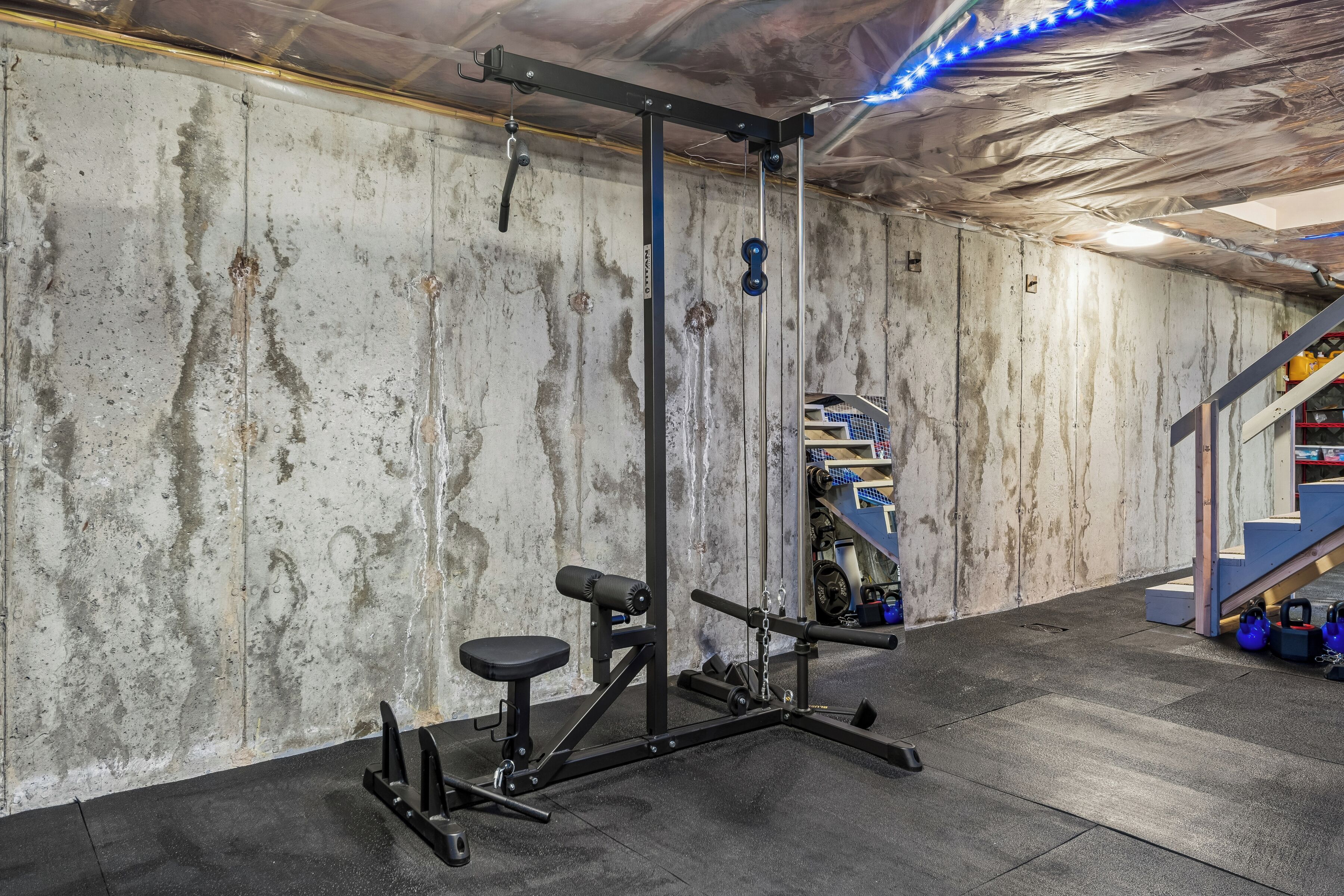 Ein Fitnessstudio mit Squat-Rack, Bankdrückbank und Gewichtsscheiben.
