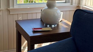 A room with a table, a lamp, and a view of the outdoors.