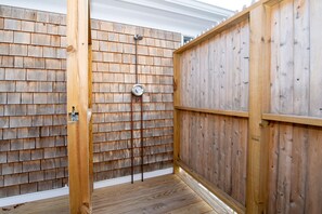 A wooden deck with a built-in shower area, a wooden fence, and a white exterior wall. - Cape Cod Ranch Retreat | Near Long Pond Beaches (Harwich)