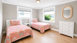 Un dormitorio con dos camas, un aparador y una ventana con persianas.