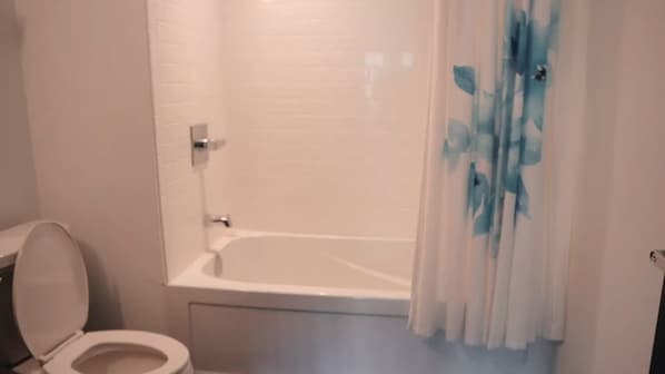 Ein Badezimmer mit Toilette, Badewanne und Duschvorhang.