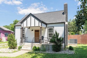 A single-story house with a front porch, a chimney, and a small front yard with a tree and a gravel path. - The Northview Nook: Fenced Yard, Dog-Friendly, & East Nashville, Near Broadway (Nashville)