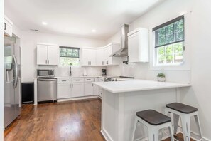 A modern kitchen with white cabinetry, a stainless steel refrigerator, a microwave, and a dishwasher. - The Northview Nook: Fenced Yard, Dog-Friendly, & East Nashville, Near Broadway (Nashville)