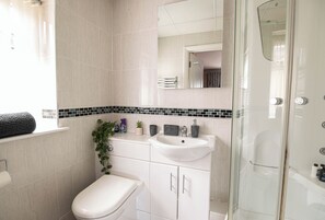Ein modernes Badezimmer mit Toilette, Waschbecken und Dusche.