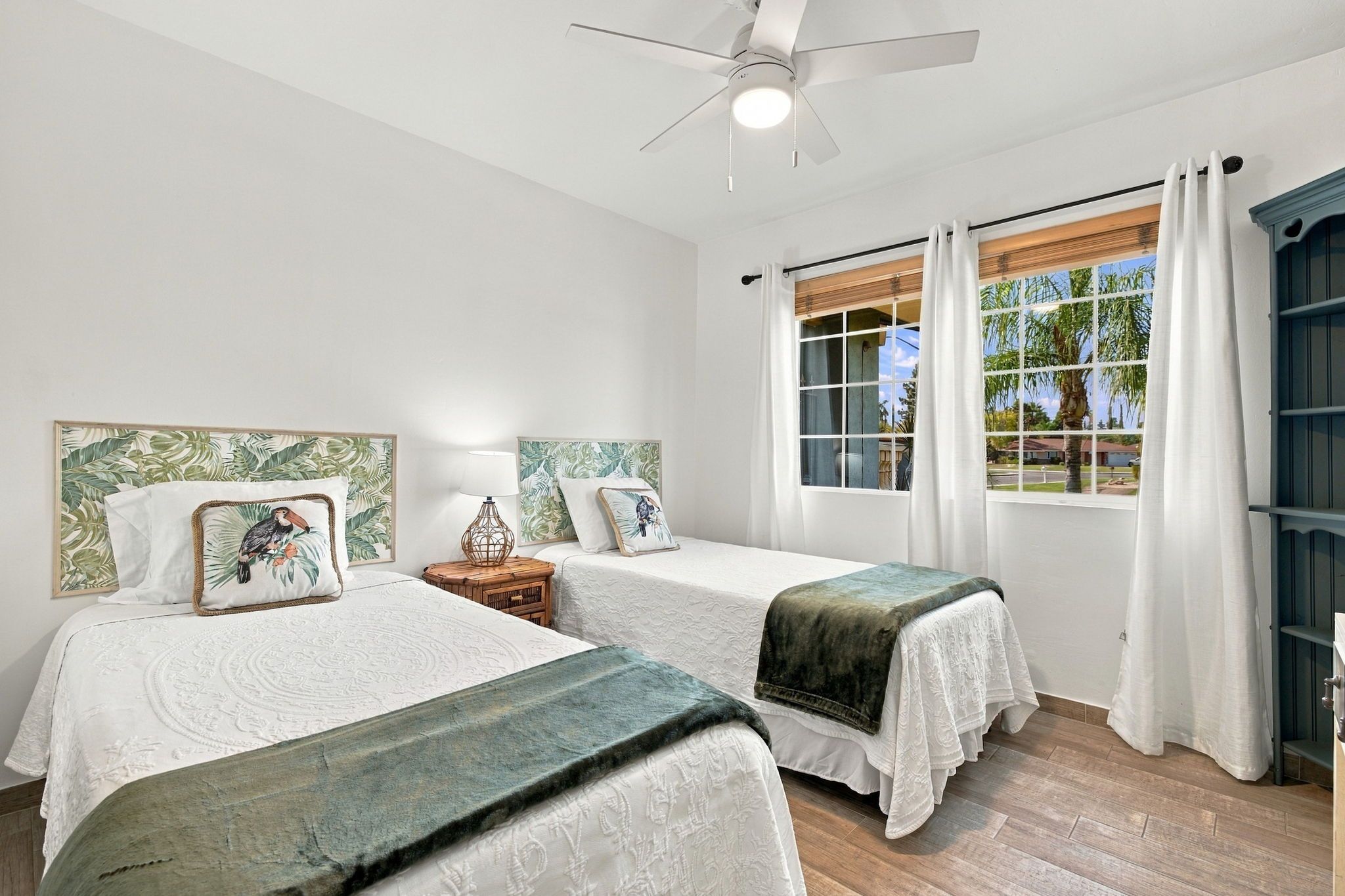 This bedroom features two comfortable beds with clean, comfortable linens, a smart TV for streaming your favorite apps, and windows overlooking the front yard.