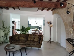 Una sala de estar con un sofá, una mesa de centro, una planta y un perchero.