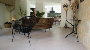 A living room with a sofa, a black chair, and a small table with a vase. - Mas in the middle of vineyards, ideally located between Camargue and Provence. (Vauvert)