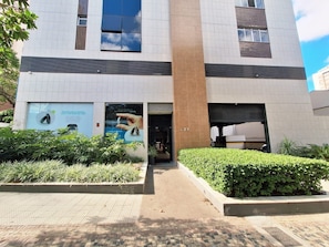 A modern building with a large entrance, a visible number 421, and a well-maintained garden area. - LK Santa Efigênia 3 (Belo Horizonte)