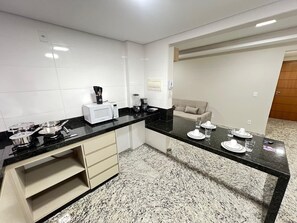 Cuina moderna amb microones, cafetera i menjador.