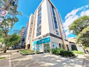 A modern building with a storefront labeled 'AUDIO+ AUDITIVOS' and a clear sky. - LK Santa Efigênia 3 (Belo Horizonte)