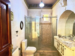 A bathroom with a toilet, shower, and sink. - Gülperi Cave Otel (Nevşehir)