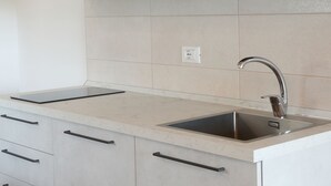 Eine Küche mit doppeltem Spülbecken, hellen Schränken und einer Arbeitsplatte.