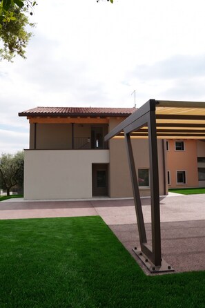 A modern two-story building with a flat roof, a balcony, and a covered outdoor area. - Apartment Conte Skyline (Veneto)