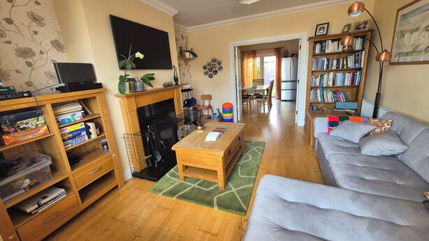 A living room with a fireplace, a sofa, a coffee table, a bookshelf, and a television. - Attractive 3-bedroom house in scenic Oranmore for your getaway (Oranmore)