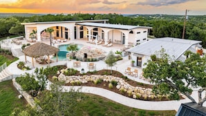 Uma casa moderna com piscina, área de estar ao ar livre e lareira de pedra.