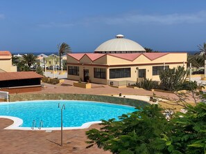 Ein Resort mit Schwimmbad, einem Gebäude mit Kuppel und Palmen.