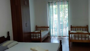 A bedroom with a large bed, a wardrobe, and a bench.