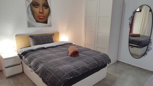 A bedroom with a bed, nightstand, wardrobe, and a mirror. - Apartment with a beautiful view and a balcony (San Marcos)