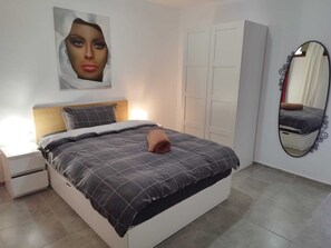 A bedroom with a bed, nightstand, wardrobe, and a mirror. - Apartment with a beautiful view and a balcony (San Marcos)