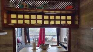 A room with a large window, a wooden lattice, and a view of a balcony with chairs and a table. - Apartment with a beautiful view and a balcony (San Marcos)
