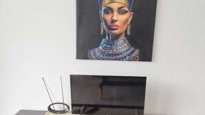 A flat-screen TV on a black entertainment unit with three drawers and a remote control on a beige cloth. - Apartment with a beautiful view and a balcony (San Marcos)