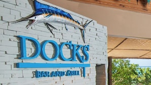Ein Restaurant namens 'DOCKS BAR AND GRILL' im maritimen Stil, inklusive einer Fischskulptur und einer Backsteinwand.