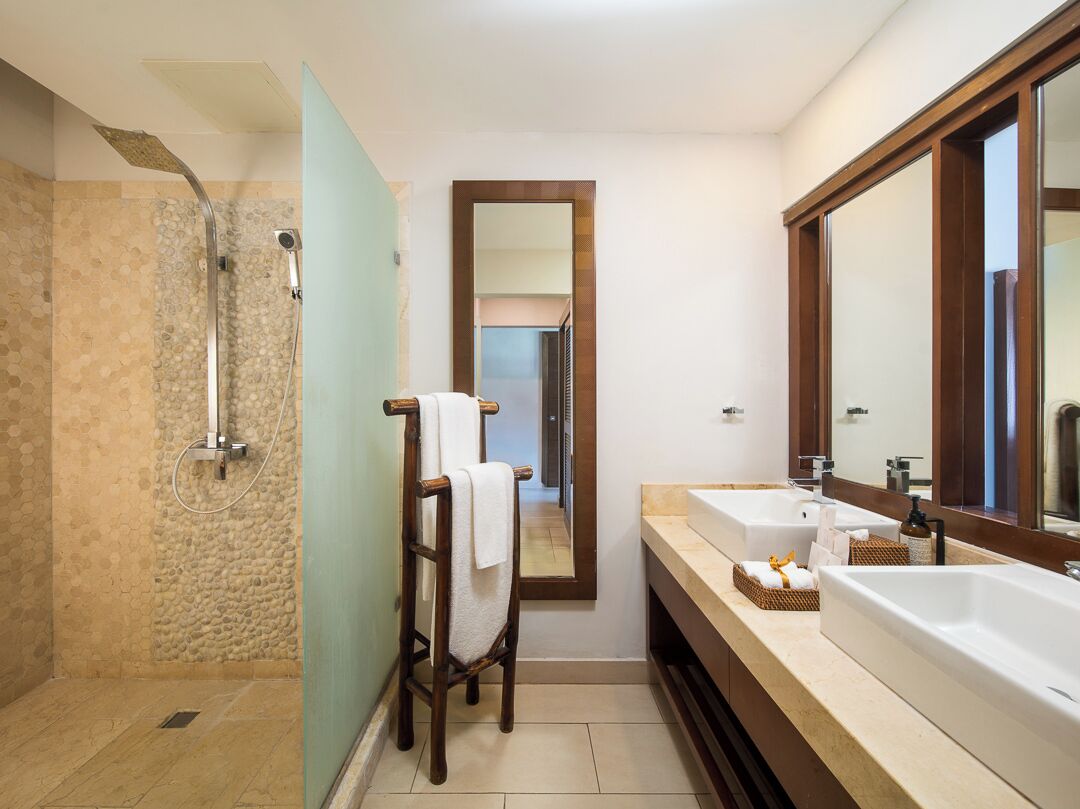 A bathroom with a shower, a towel rack, a sink, and a mirror.