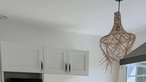 A modern kitchen with white cabinets, a microwave, a toaster, and a coffee maker. - Meschers. Beach within walking distance, garden & terrace (Meschers-sur-Gironde)