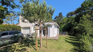 A house with a garage, a lawn, and a tree in front. - Meschers. Beach within walking distance, garden & terrace (Meschers-sur-Gironde)