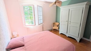 A bedroom with a bed, a chair, a wardrobe, and a window. - Meschers. Beach within walking distance, garden & terrace (Meschers-sur-Gironde)