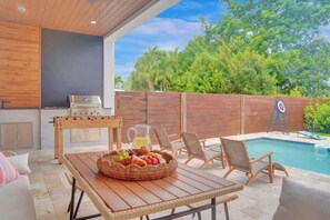 An outdoor patio with a pool, a foosball table, and a grill. - Las Olas-8 BD with Two HTD Pool-Jacuzzi-BBQ-Games (Fort Lauderdale)