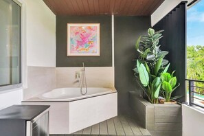 A modern bathroom with a bathtub, a large window, and a potted plant. - Las Olas-8 BD with Two HTD Pool-Jacuzzi-BBQ-Games (Fort Lauderdale)