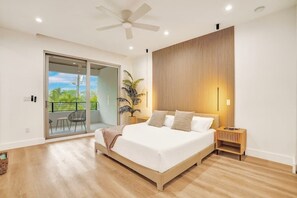 A bedroom with a bed, a ceiling fan, a nightstand, a potted plant, and a sliding glass door leading to an outdoor area. - Las Olas-8 BD with Two HTD Pool-Jacuzzi-BBQ-Games (Fort Lauderdale)