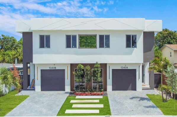 A modern two-story house with a garage, a well-maintained lawn, and a clear sky. - Las Olas-8 BD with Two HTD Pool-Jacuzzi-BBQ-Games (Fort Lauderdale)