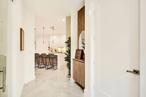 Eine moderne Küche mit Barhocker, einem Holzschrank und einem Willkommensschild.