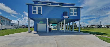 Un edificio blu con ingresso coperto, una insegna e una piccola area esterna.
