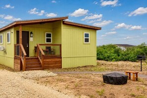 Ein eingeschossiges Gebäude mit Veranda, Holzstufen und einem kleinen Tisch.