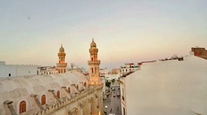 A cityscape with two prominent towers and a street below. - Marhaba Casbah (Algiers)