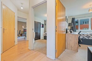 Eine moderne Wohnung mit Holzboden, einer Küchenzeile, einem Essbereich und einem großen Fenster.
