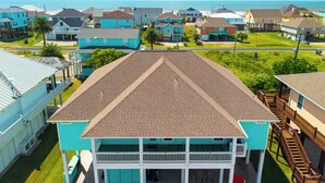A coastal residential area with multiple two-story houses, a clear view of the ocean, and a well-maintained lawn. - Crystal Beach Oasis, Hot Tub, 2 Decks, 2 Main Suites, Walk to the Beach, Dogs (Bolivar Peninsula)