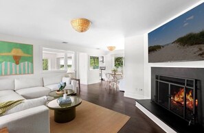Ein modernes Wohnzimmer mit Kamin, einer Couch, einem Couchtisch und einem Essbereich.