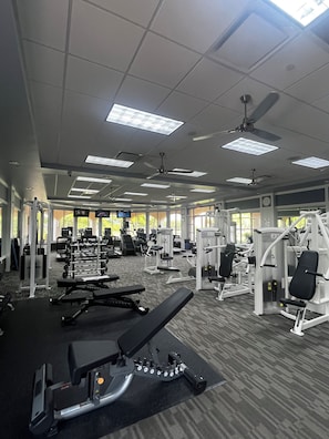 A gym with ceiling fans, exercise equipment, and large windows. - Sarasota Paradise in VillageWalk 2 Pools, Tennis, Pickleball, Fitness & Dining (Sarasota)