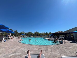 A pool area with lounge chairs and umbrellas. - Sarasota Paradise in VillageWalk 2 Pools, Tennis, Pickleball, Fitness & Dining (Sarasota)