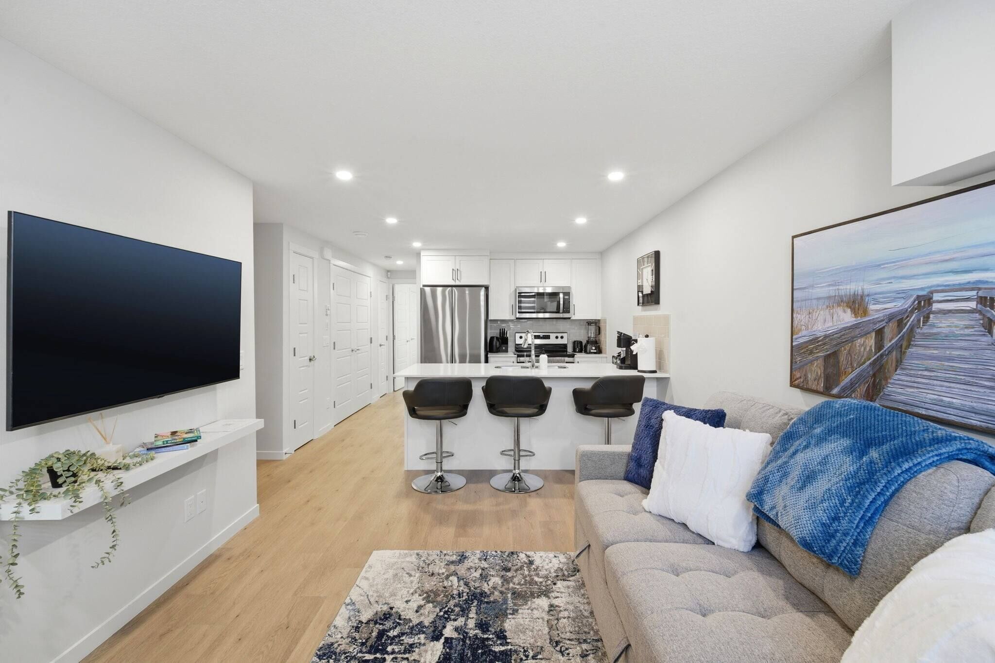 A modern apartment with a kitchen, dining area, and living room.