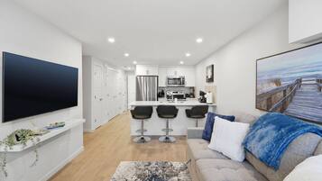 A modern apartment with a kitchen, dining area, and living room.