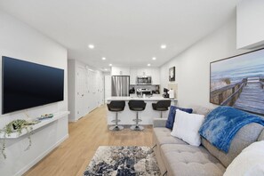 A modern apartment with a kitchen, dining area, and living room. - Livingston Haven - Modern 1BR Private Suite (Calgary)