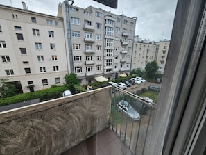 Un immeuble d’habitation à plusieurs étages, doté de balcons et avec des voitures garées devant.